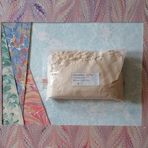 Peut inclure: Un sac en plastique transparent rempli d'une poudre beige étiquetée "Marbled Gifts Carrageenan for marbling size".