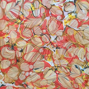May include: Abstract pattern with a marbled effect. The design features swirling shapes in shades of red, brown, yellow, and white. The pattern has a dynamic, organic feel, suitable for various applications.