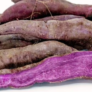 Puede incluir: Primer plano de varias batatas moradas, algunas con la piel retirada para revelar la pulpa morada vibrante.