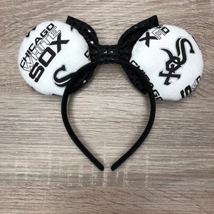 May include: Black headband with white fabric mouse ears featuring the Chicago White Sox logo. The ears are decorated with black sequins.