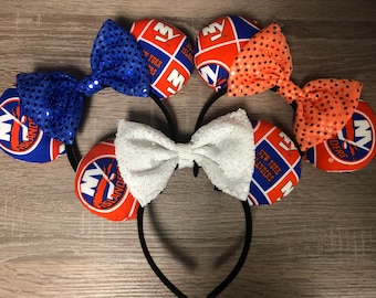 Op de afbeelding: Een set van drie paar handgemaakte muisoren met het logo van de New York Islanders. Elk paar heeft een andere strik: blauw, wit en oranje.