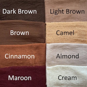 Op de afbeelding: Een raster van acht stoffen stalen met een gekreukte textuur, gelabeld met de kleuren Dark Brown, Light Brown, Brown, Camel, Cinnamon, Almond, Maroon en Cream. Elke staal toont een afzonderlijke tint bruin, beige of gebroken wit in een raster.