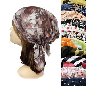 May include: A head scarf featuring a brown and white floral pattern tied at the back. The scarf is displayed on a mannequin head. A vertical column on the right side shows a variety of other head scarves with different patterns and colors.