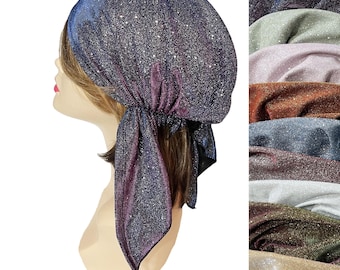 Puede incluir: Un pañuelo brillante en tonos azules, morados y plateados, exhibido en una cabeza de maniquí. La tela tiene una textura brillante. A la derecha se muestra una selección de telas similares en varios colores.