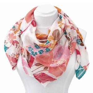 May include: A lightweight square scarf featuring a white base with a colorful floral print in shades of coral, pink, mustard yellow, and teal. The pattern consists of various stylized flowers and leaves distributed across the fabric surface.