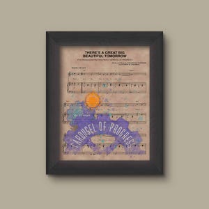 May include: Framed print featuring sheet music with the text "THERE'S A GREAT BIG BEAUTIFUL TOMORROW" and "CAROUSEL OF PROGRESS." The artwork includes watercolor accents in purple, blue, and orange, set against a vintage paper background.
