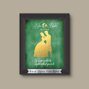 May include: A framed print with a black frame. The print features a gold foil silhouette of a couple dancing on a green textured background. The names "Joe & Rachel" and the date "05.12.2018" are above the couple. The text "My dream wouldn't be complete without you in it" is below.