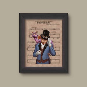 May include: A framed print of a musical score for the song "One Little Spark" from Disney's "Journey Into Imagination". The print features an illustration of a man in a blue suit and top hat with a purple dragon on his shoulder.