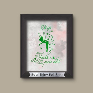 May include: A framed print with a green silhouette of Tinkerbell, the fairy from Peter Pan, with the text "All you need is faith and a little pixie dust". The name "Eliza" is at the top of the print. The print has a pink and gray marbled background and a silver foil border.
