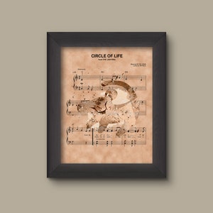 May include: A framed print of the song "Circle of Life" from the movie The Lion King. The sheet music is printed on a vintage-looking paper with a watercolor-style image of Simba, the lion cub, in the background.