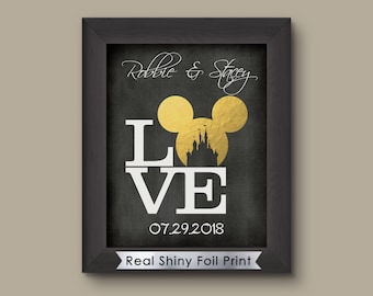 May include: A black framed print with a gold Mickey Mouse head and the word "LOVE" in white letters. The print also includes the text "Robbie & Stacey" and "07.29.2018". The bottom of the print reads "Real Shiny Foil Print".