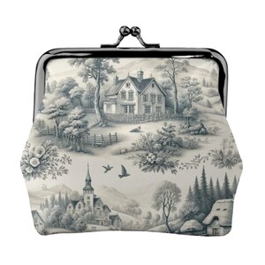 May include: A coin purse with a black metal frame and clasp, featuring a black and white landscape toile pattern. The pattern depicts a village scene with houses, trees, and hills. The purse is a classic accessory.
