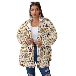 May include: Cream-colored zip-up jacket featuring a detailed insect pattern in various colors. The jacket has a white interior lining and is worn open, revealing a white top. The design includes butterflies, beetles, and other insects.