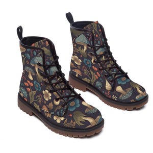 Two lace-up boots with a dark pattern of mushrooms and flowers are positioned at a three-quarter angle against a white background.