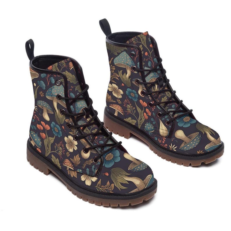 Two lace-up boots with a dark pattern of mushrooms and flowers are positioned at a three-quarter angle against a white background.
