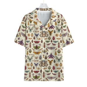 May include: Short-sleeved button-down shirt with a cream-colored background and a repeating pattern of various insects in shades of brown, green, red, and purple. The shirt has a classic collar and a relaxed fit.