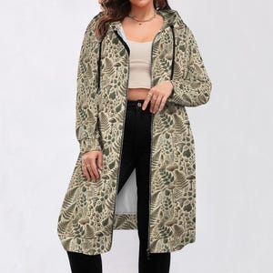 May include: A long-sleeved hooded jacket with a zip closure. The jacket is beige with a pattern of green leaves and mushrooms.