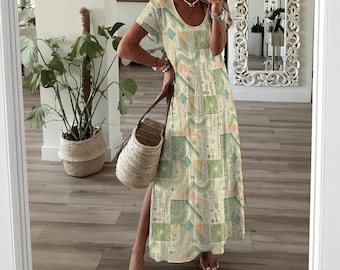 May include: A long, flowing dress with a geometric pattern in shades of green, blue, and peach. The dress has short sleeves and a scoop neckline. A woven tote bag is held in the hand. The dress has a side slit.