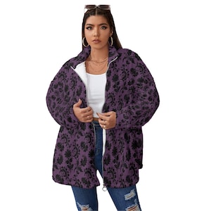 May include: A purple zip-up jacket with a black floral pattern. The jacket has a white interior lining and a full-length zipper. The model is wearing the jacket over a white top and blue jeans.