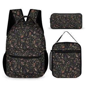 May include: A black backpack, a rectangular pencil case, and a lunch bag, all featuring a repeating pattern of bats, mushrooms, small flowers, and crescent moons. Each item has black zips and black trim, with the backpack including side mesh pockets.