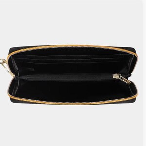 May include: Black zippered wallet with gold zipper pulls. The wallet is open and the interior is visible.