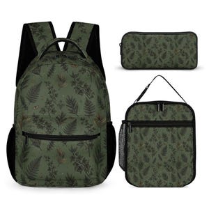 Op de afbeelding: Een donker olijfgroene rugzak, een rechthoekig etui en een lunchtas, allemaal voorzien van een herhalend botanisch patroon van donkere varens, klimopbladeren en kleine gouden accenten. Elk item heeft zwarte ritsen en zwarte mesh zijvakken.