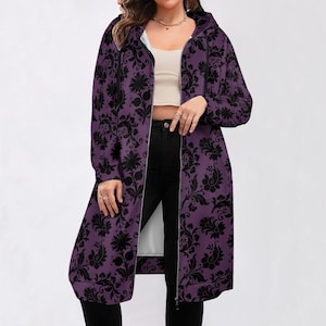 May include: A long purple hooded sweatshirt with a black floral pattern. The sweatshirt has a zipper closure and a relaxed fit.
