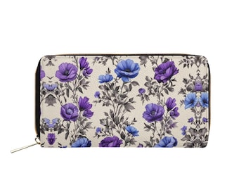 Op de afbeelding: Een crèmekleurige rits portemonnee met een bloemenpatroon met paarse en blauwe bloemen op een witte achtergrond.