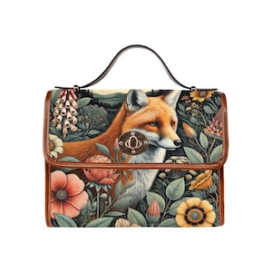 May include: A brown leather handbag featuring a fox and floral print. The fox is orange and white and is surrounded by flowers in shades of pink, yellow, and green.