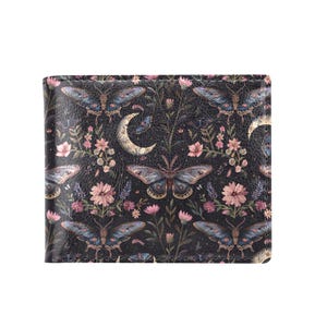 May include: A black wallet with a repeating pattern of blue butterflies, pink flowers, and crescent moons. The wallet is rectangular and appears to be made of leather or a similar material. The design is detailed and intricate, with a vintage or bohemian aesthetic.