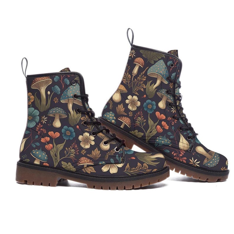 A pair of black lace-up ankle boots featuring a vintage botanical pattern with mushrooms and colorful flowers viewed from the side.