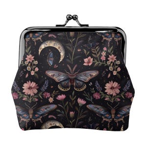 Puede incluir: Un monedero con cierre negro con un patrón floral y de insectos detallado. El diseño presenta polillas, mariposas, lunas crecientes y flores rosas sobre un fondo oscuro. El bolso tiene un cierre de metal negro.