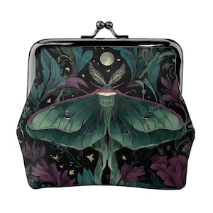 Pode incluir: Uma bolsa preta com fecho de metal. A bolsa apresenta uma ilustração detalhada de uma mariposa verde com uma lua cheia e estrelas em um fundo escuro com folhagem roxa e verde-azulado.
