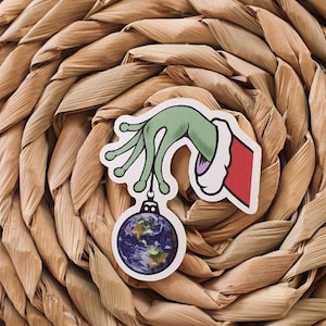 Christmas Ball Sticker. Alien Hand Holding Earth. Christmas Ornaments. Christmas Decorations. Trippy Xmas Sticker.