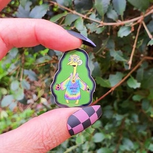 May include: A sticker featuring a cartoon character with a tie-dye shirt and the text "Bring You Love". The character has large eyes and a long neck. The sticker is on a green background.