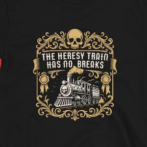 May include: Black t-shirt featuring a detailed graphic with a skull, ornate frame, and a vintage train. The text reads "THE HERESY TRAIN HAS NO BRAKES". The design is in gold and white, set against a black tee.