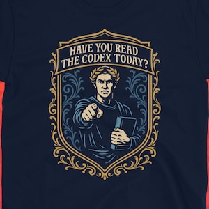 Puede incluir: Camiseta azul marino con un diseño gráfico de una figura de estilo romano señalando. El diseño incluye el texto "HAVE YOU READ THE CODEX TODAY?" en un marco decorativo. El logotipo de Dungeon Arsenal está en la parte inferior.