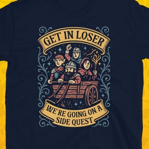 May include: Navy blue t-shirt with a colorful graphic of a fantasy scene. The design features a cart with four characters and the text "GET IN LOSER WE'RE GOING ON A SIDE QUEST". The shirt is set against a yellow skull pattern.