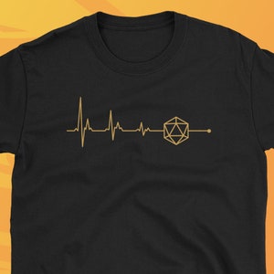 Könnte beinhalten: Schwarzes T-Shirt mit einer goldenen Umrandung eines Herzschlags und eines 20-seitigen Würfels. Der Text "dungeonarsenal.etsy.com" befindet sich am unteren Rand des Shirts.