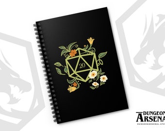May include: A black spiral notebook with a floral design featuring a twenty-sided die, green leaves, and yellow and white flowers. The notebook has the text "Dungeon Arsenal" and a website address.