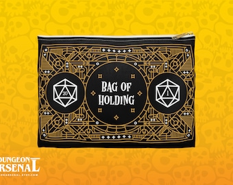Puede incluir: Bolsa negra con cremallera con un diseño geométrico dorado y el texto "Bag of Holding". La bolsa presenta dos dados blancos, uno con un 20 y el otro con un 1.