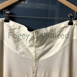 May include: A white cotton garment with a button closure and a text label that reads "Foggy Unlimited".