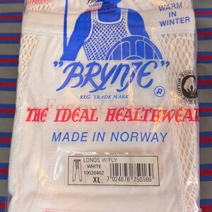 Puede incluir: Ropa interior larga blanca con bragueta, etiquetada con "Brynje" y "The Ideal Healthwear Made in Norway". El paquete también incluye un código de barras y el texto "Longs W/Fly White 10020402 XL 7 024876 750169".