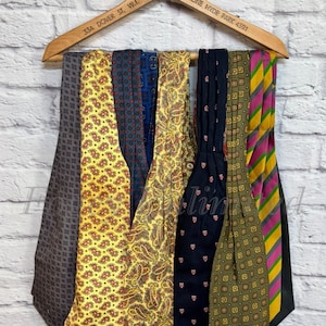 Puede incluir: Una colección de ocho corbatas estampadas colgadas de una percha de madera. Las corbatas son de varios colores, incluyendo amarillo, azul, verde y morado. La percha tiene el texto "33A DOVER ST, W.1. CLGOUR FRENCH STANBURY. PHONE HYDE PARK 4591" impreso en ella.
