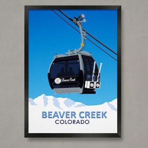 Op de afbeelding: Een zwart ingelijste poster met een blauwe lucht als achtergrond en een witte gondel met de tekst "Beaver Creek" aan de zijkant. De gondel hangt aan een kabel en vervoert skiërs. De tekst "Beaver Creek Colorado" staat onderaan de poster.