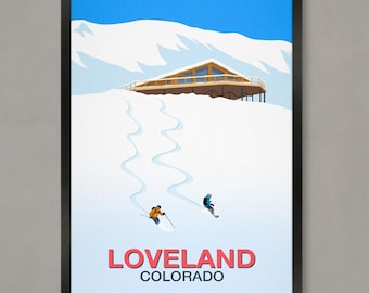 May include: A black framed poster with a blue sky and snowy mountain scene. Two skiers are skiing down a slope towards a wooden cabin with the text "LOVELAND COLORADO" at the bottom.