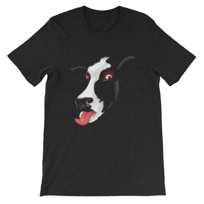 May include: A black t-shirt featuring a graphic of a cow's face with red eyes and its tongue sticking out.
