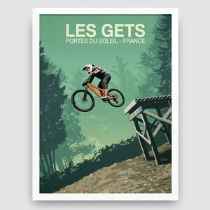 May include: A vintage-style poster with a green background featuring a mountain biker in mid-air, performing a trick on a dirt jump. The poster has the text "LES GETS" and "PORTES DU SOLEIL - FRANCE" in white.
