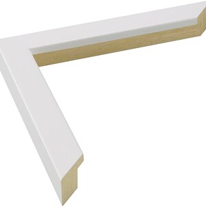 May include: White picture frame with a wood core. The frame has a simple, clean design.