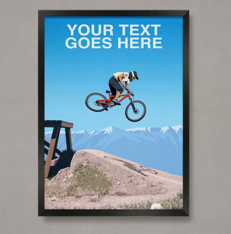 May include: A mountain biking poster featuring a cyclist in mid-air, performing a trick on a red mountain bike. The cyclist is wearing a helmet and a white shirt. The background features a blue sky, mountains, and a dirt path.